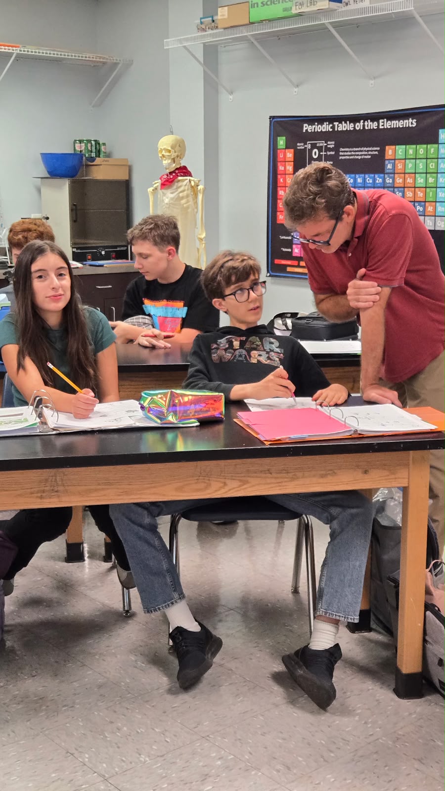 Teacher working one-on-one with students in a Trinity Prep science classroom